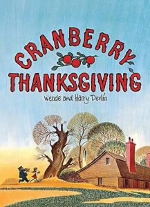 Cover of Cranberry Thanksgiving by Wende and Harry Devlin — Maggie and her grandmother holding a loaf of cranberry bread beside the sea.